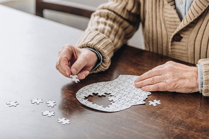 Photo of senior citizen solving jigsaw puzzle